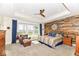 Bright main bedroom featuring a wood accent wall, sitting area, and large windows offering natural light at 10151 E 191St St, Noblesville, IN 46060