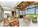 Spacious covered patio with a dining area, cozy seating, an outdoor fireplace, TV, and a relaxing hot tub at 10151 E 191St St, Noblesville, IN 46060