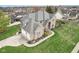 Stunning aerial view of a brick home with a manicured lawn, mature trees, and a three-car garage at 10157 Woods Edge Dr, Fishers, IN 46037