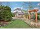 Manicured backyard with a pergola and mature trees offering a serene and private outdoor space at 10157 Woods Edge Dr, Fishers, IN 46037