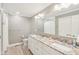 Bright bathroom featuring double sinks with granite countertops, modern lighting, and a large mirror at 10157 Woods Edge Dr, Fishers, IN 46037