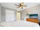 Comfortable bedroom with neutral walls, ceiling fan, a dresser with a TV on top, and a closet at 10157 Woods Edge Dr, Fishers, IN 46037