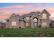 A brick two-story home with a blue front door and arched entryway is nestled in a lush green yard at 10157 Woods Edge Dr, Fishers, IN 46037