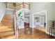 The foyer features hardwood floors, a staircase, a plant, and a view of the living room at 10157 Woods Edge Dr, Fishers, IN 46037