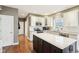 Well-lit kitchen with an island, white cabinetry, hardwood floors, and modern appliances at 10157 Woods Edge Dr, Fishers, IN 46037
