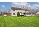 Picture of house from the yard, with patio, manicured lawn, and sunroom at 10234 Leeward Blvd, Indianapolis, IN 46256