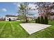 A spacious backyard featuring a basketball court, manicured lawn, and lush greenery providing an ideal space for recreation at 10234 Leeward Blvd, Indianapolis, IN 46256