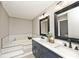 Bathroom with double vanity, bathtub, and tiled walls at 10234 Leeward Blvd, Indianapolis, IN 46256