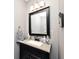 A half bathroom features a vanity with a black cabinet, a gray wall, and a mirror at 10234 Leeward Blvd, Indianapolis, IN 46256