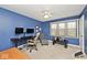 Bright bedroom with blue walls, ceiling fan, large window, and office space at 10234 Leeward Blvd, Indianapolis, IN 46256