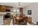 A formal dining room includes wood floors, a wood table, and a modern chandelier at 10234 Leeward Blvd, Indianapolis, IN 46256