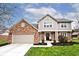 Charming brick and siding two-story home with a well-manicured lawn and attached two-car garage at 10234 Leeward Blvd, Indianapolis, IN 46256