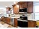 Kitchen with stainless steel appliances, wood cabinets, and granite countertops at 10234 Leeward Blvd, Indianapolis, IN 46256