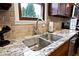 This kitchen features a double sink with granite countertops and wood cabinets at 10234 Leeward Blvd, Indianapolis, IN 46256