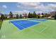 Outdoor tennis courts with blue playing surfaces, framed by green surroundings, perfect for recreational and competitive play at 10234 Leeward Blvd, Indianapolis, IN 46256