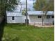 Backyard with a utility shed, a lush green lawn, and scattered trees at 1024 Foltz St, Indianapolis, IN 46241