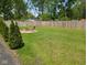 Spacious backyard featuring a fire pit, wooden fence, and lush green grass, perfect for outdoor entertaining at 1024 Foltz St, Indianapolis, IN 46241