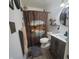Bathroom with a vanity, round mirror, patterned shower curtain with mounted shelving and decorative lighting at 1024 Foltz St, Indianapolis, IN 46241