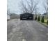 Detached metal carport structure with two cars inside, and paved driveway at 1024 Foltz St, Indianapolis, IN 46241
