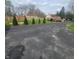 View of a spacious driveway and wooden deck for outdoor gatherings, surrounded by mature trees at 1024 Foltz St, Indianapolis, IN 46241