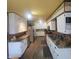 Open kitchen with wood-look flooring, white cabinets, and stainless steel appliances at 1024 Foltz St, Indianapolis, IN 46241
