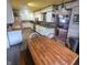 Kitchen connected to the dining area with a wooden table, white cabinets, and stainless appliances at 1024 Foltz St, Indianapolis, IN 46241
