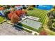 A high-angle shot displays a community park with a basketball court, playground, and green spaces near a pond at 10401 Monarch Ct, Noblesville, IN 46060
