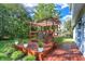 Well-maintained backyard with a wood deck, pergola, flower pots, and lush greenery at 10401 Monarch Ct, Noblesville, IN 46060