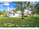 Exterior view of a house with a large backyard, deck with pergola, play structure, and mature trees at 10401 Monarch Ct, Noblesville, IN 46060