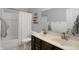 Bright bathroom featuring double sinks, wood cabinets, shower with curtain, and tiled floors at 10401 Monarch Ct, Noblesville, IN 46060
