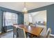 Formal dining room features chandelier, wood table with seating for six, and a large window at 10401 Monarch Ct, Noblesville, IN 46060