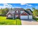 Charming brick home featuring a three-car garage and a well-manicured lawn at 10401 Monarch Ct, Noblesville, IN 46060
