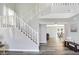 Grand foyer with a staircase, wood-look floors, and views into the kitchen and living room at 10401 Monarch Ct, Noblesville, IN 46060