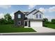 Charming two-story home featuring a mix of brick and siding, set against a lush green lawn at 10554 Crystal Coop Ln, Indianapolis, IN 46235