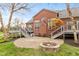 Brick home with a deck and patio including an outdoor fire pit and a dog house at 10611 Proposal Pointe Way, Fishers, IN 46040