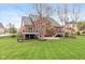 Rear exterior view showcases the tiered deck and brick house on a sprawling green lawn at 10611 Proposal Pointe Way, Fishers, IN 46040