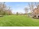 Extensive backyard with lush green grass and mature trees leads to a tiered deck and patio area at 10611 Proposal Pointe Way, Fishers, IN 46040