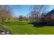 Large, lush backyard with mature trees and play equipment, ideal for outdoor enjoyment and relaxation at 10611 Proposal Pointe Way, Fishers, IN 46040