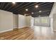 Finished basement boasts wood-look flooring, neutral walls, and two bright windows for natural light at 10611 Proposal Pointe Way, Fishers, IN 46040