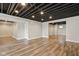 Spacious finished basement showcasing wood-look floors, open ceiling, and recessed lighting at 10611 Proposal Pointe Way, Fishers, IN 46040