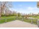 Backyard deck view with a pond, trees, and red swing set at 10611 Proposal Pointe Way, Fishers, IN 46040