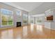 Bright living room with large windows, fireplace, and open concept to kitchen and dining area at 10611 Proposal Pointe Way, Fishers, IN 46040