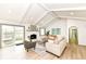 Bright, open-concept living room with vaulted ceilings, fireplace, hardwood floors, and seamless flow to the backyard at 107 Northwood Dr, Fishers, IN 46038