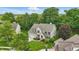 Aerial view of brick home with well-manicured lawn, mature trees, and a two car garage at 11974 Volcanic Rock Dr, Fishers, IN 46037