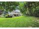 Expansive backyard featuring lush lawn, mature trees, and a charming playset; perfect for Gathering fun at 11974 Volcanic Rock Dr, Fishers, IN 46037
