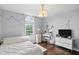 This bright bedroom offers a cozy bed, hardwood floors, and a window with natural light at 11974 Volcanic Rock Dr, Fishers, IN 46037