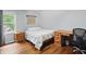 Bright bedroom with hardwood floors, a wooden desk, and a bright window at 11974 Volcanic Rock Dr, Fishers, IN 46037