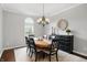 Bright dining room with an oval table set for six under a chandelier and a buffet at 11974 Volcanic Rock Dr, Fishers, IN 46037