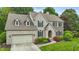 Stunning two-story brick home with a well-manicured lawn, mature trees, and a charming entryway at 11974 Volcanic Rock Dr, Fishers, IN 46037