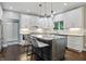 Modern kitchen featuring granite countertops, gray island with bar seating, and stainless steel appliances at 11974 Volcanic Rock Dr, Fishers, IN 46037
